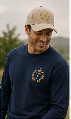 Man wearing a navy embroidered sweatshirt and coordinating cap.